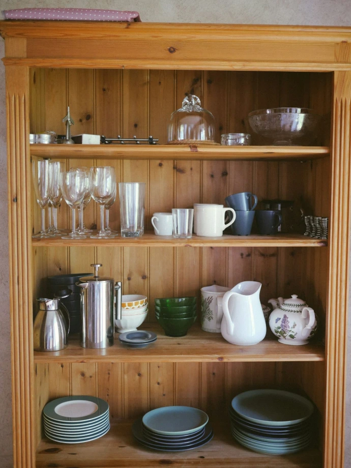Wooden shelves filled with kitchenware and glassware.